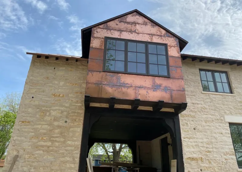 Copper metal panel facade on a stone building for Skylight Installation in Mashpee
