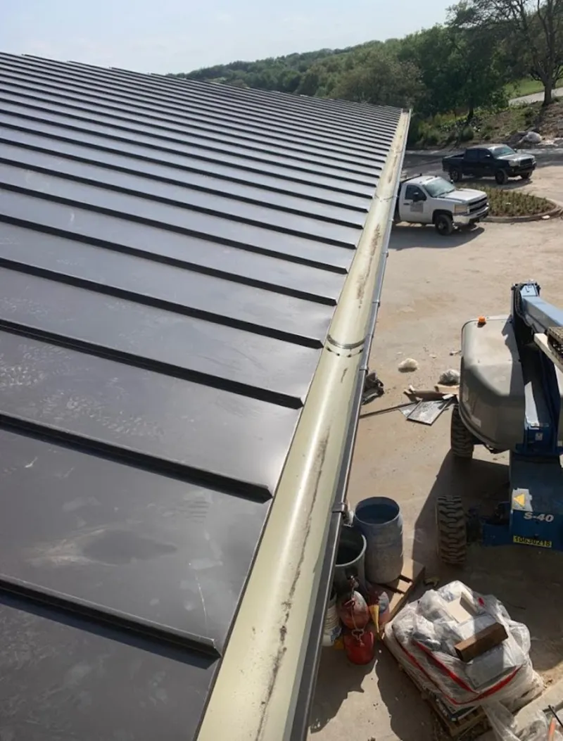 Standing seam panel and gutter detail on a metal roofing jobsite in Mashpee
